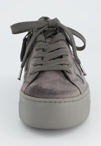 Baskets en daim gris avec une semelle en caoutchouc gris épais, dotées de lacets plats et de zips sur les côtés pour le détail. Texture lisse avec un design bas.