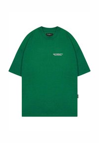 Camiseta de algodón verde con un corte relajado, mangas cortas, escote redondo y texto impreso "DEPARTAMENTO CREATIVO RETERNITY" en blanco.