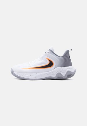 Pantof sportiv alb și gri cu logo în formă de swoosh portocaliu și negru, talpă texturată și guler căptușit pentru gleznă, pe un fundal simplu.