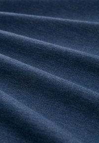 Donkerblauwe textuurstof met subtiele variaties in tint, met zachte, gladde golven en een fijn weefpatroon door het geheel.