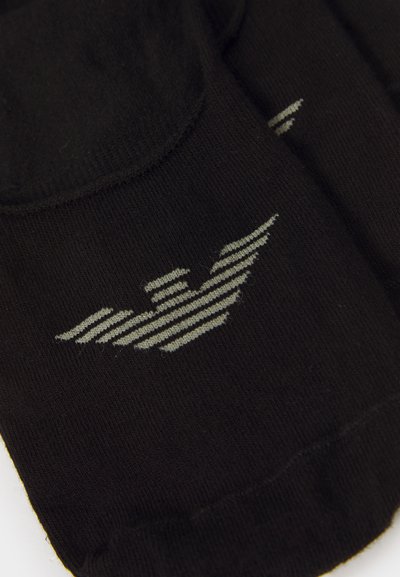 Chaussettes noires en tissu doux avec un logo d'aile rayé gris. Le design est simple, avec un ajustement serré et des poignets côtelés.