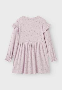 Abito viola con maniche lunghe, caratterizzato da accentuazioni volant sulle spalle e vita arricciata. Decorato con motivi a pois dorati su una texture a costine.
