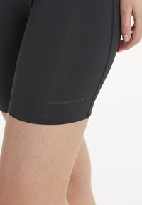 Zwarte sportshorts gemaakt van rekbaar materiaal met een soepele textuur. Heeft een subtiele "ENDURANCE"-logo dichtbij de zoom en een aansluitend ontwerp.