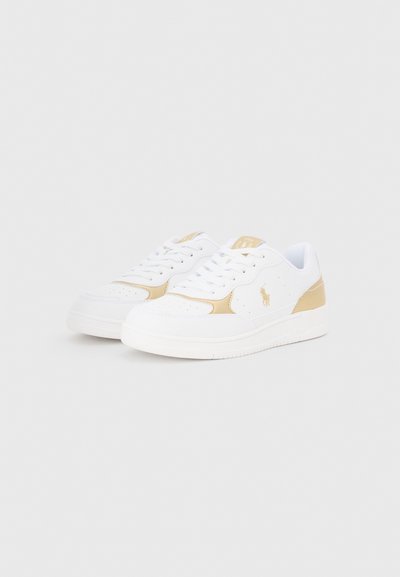 Vita sneakers med guldaccenter, slät läderyta, perforerade detaljer, platta snören och en texturerad gummisula.