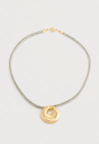 Zilveren ketting met een gladde, ronde gouden hanger met een open midden en een gouden magneetslot.