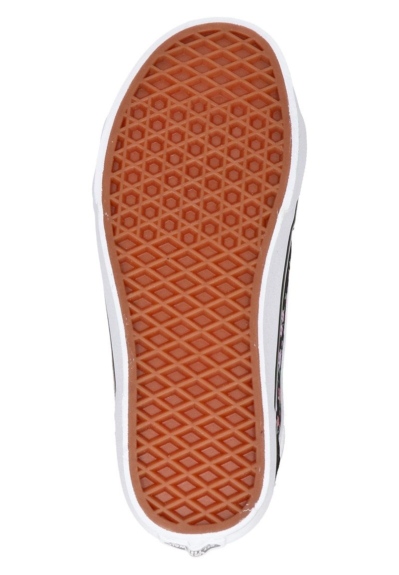 Suela de zapato con un patrón de ondulación de goma marrón y borde blanco, vista desde abajo contra un fondo blanco.