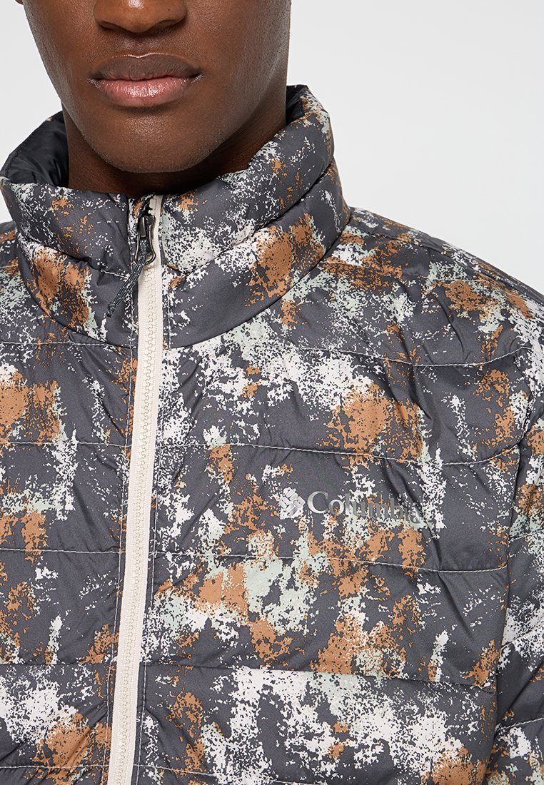 Pikowana szara kurtka z wielokolorowym abstrakcyjnym wzorem w brązie, bieli i zieleni. Posiada wysoki kołnierz oraz zamek błyskawiczny z przodu. Widoczne logo Columbia.
