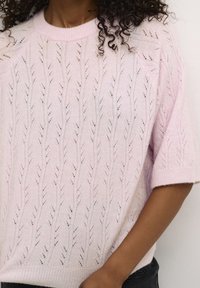 Jasnoróżowy sweter z dzianiny z wzorem liści, krótkimi rękawami, prążkowanym dekoltem i dołem, o miękkiej fakturze i luźnym kroju.