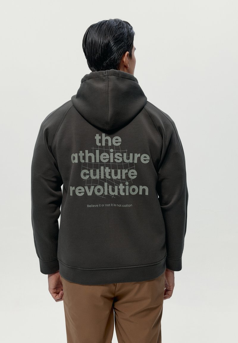 Tmavošedá mikina s klokankou a kapucňou. Veľký text na zadnej strane obsahuje "revolúcia kultúry athleisure" svetlošedým písmom.