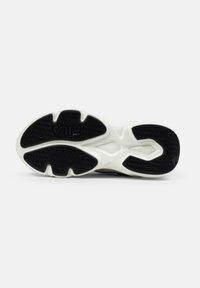 Suola di sneaker in gomma bianca e nera con motivo a spina di pesce e logo "FILA" sulla parte anteriore.