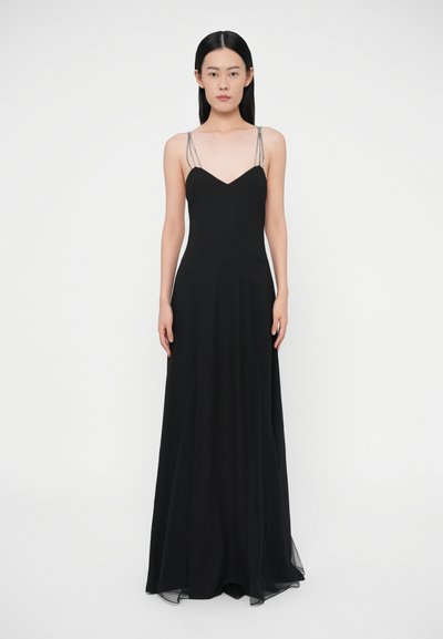 Black evening gown with a fitted bodice, V-neck, and long flowing skirt. Features delicate beaded straps and a smooth, lightweight fabric.