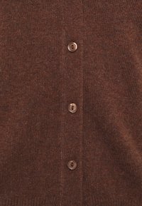 Cardigan en tricot marron avec un col en V, cinq boutons marron et une finition douce et texturée. Idéal pour superposer par temps frais.