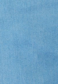 Tela de mezclilla azul claro con una textura suave y un sutil patrón de sarga, que presenta un color uniforme y un acabado suave.