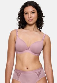 Mauve podprsenka s hlubokým výstřihem a krajkovými detaily na ramínkách a středu, se hladkým materiálem a tvarovanými košíčky. Spárováno s odpovídajícími vysokými kalhotkami.