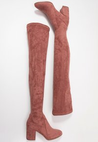 Botki do ud w różowym zamszu z szerokim obcasem. Gładka tekstura, dopasowany krój i detale na górnej szwie.