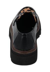 Scarpa in pelle nera con suola cucita color marrone. L'interno presenta un motivo a stelle marrone e nera, con un accento metallico all'apertura.