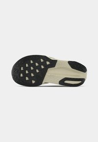 Suela de zapato con una base de goma negra y un patrón texturizado, además de una entresuela de color crema. Un notable diseño de banda de rodadura geométrica mejora la tracción.