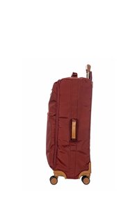 Valise à roulettes bordeaux avec extérieur en tissu, accents beige, poignée rétractable et roues à roulement fluide ; dispose d'une poche zippée sur le côté.