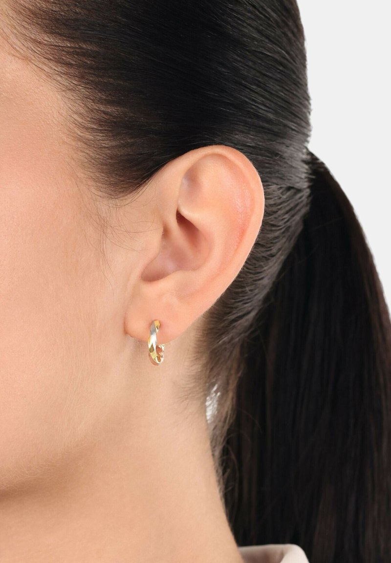 Guldörhänge med en vriden design. Slät metallisk yta, liten storlek och blank finish. Bärs i örsnibben.