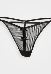 Fio dental preto com parte de trás em rede, detalhes brilhantes e pequenos laços. As alças finas formam um design cruzado com um detalhe em metal.