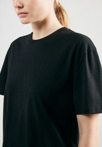 Zwarte katoenen t-shirt met korte mouwen, voorzien van een klassieke ronde hals, een gladde textuur en een relaxed fit. Geen zichtbare patronen of graphics.