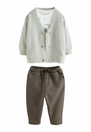 Cardigan gri din bumbac cu nasturi din lemn, peste un maiou alb cu un grafic de mașină. Pantaloni joggeri tricotati maro cu talie elastică și buzunare.