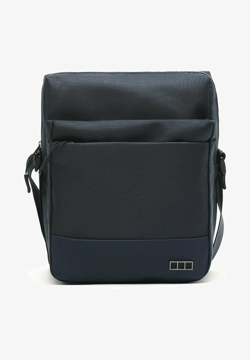 Námornícky modrá taška cez rameno s textúrovanou látkou, prednou zipsovou vreckom, nastaviteľným popruhom a malým značkovým akcentom v pravom dolnom rohu.