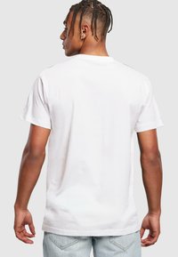 Hvid bomulds T-shirt med rund hals og korte ærmer, i en afslappet pasform uden synlig branding eller mønstre.