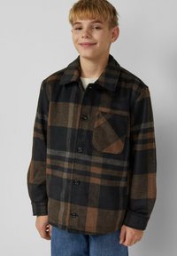 Black and brown plaid flannel shirt with a button-down front, pointed collar, and a chest pocket. It has a textured fabric.