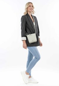 Borsa a tracolla in pelle grigia chiara, forma rettangolare, tracolla regolabile, superficie liscia, design minimalista, logo in rilievo sul davanti.