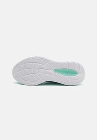 Semelle en caoutchouc blanc pour chaussures de sport avec un motif texturé, dotée d'une accentuation vert menthe pour une meilleure adhérence et flexibilité.