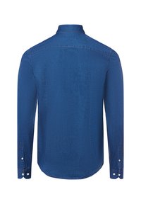 Camicia in denim blu a maniche lunghe con colletto, chiusura a bottone ai polsini e orlo leggermente curvo. Texture liscia e colore uniforme.