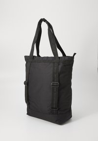 Black tote bag made of textured fabric, featuring dual handles and adjustable straps. Simple design with no visible hardware or patterns.