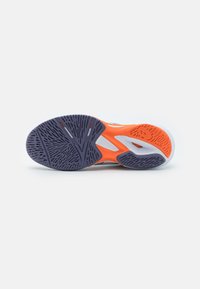Sålen på skoen har et lilla og oransje fargevalg med teksturerte mønstre for grep. Den er laget av gummi og har et glatt, fleksibelt design.