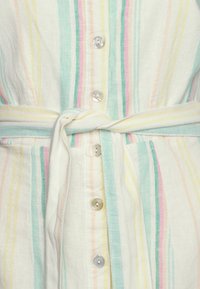 Randig skjortklänning i lätt tyg; har pastellfärger, knapprad fram och ett knutet midjeband med silkeslen textur och släta knappar.