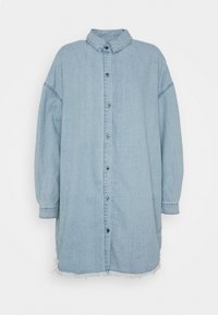 Robe chemise en denim surdimensionnée bleu clair avec des manches longues, un devant à boutons, un col et un ourlet effiloché.