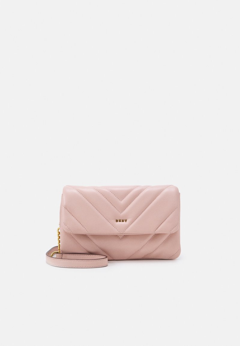 Pochette en cuir matelassé rose clair avec fermeture à rabat, logo doré et anse de poignet amovible avec détail chaîne sur un fond uni.