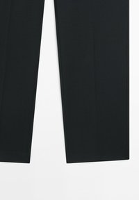 Lower portion of black tailored formal trousers with straight hems on a white background.