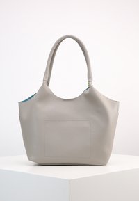 Szara skórzana torba typu tote o teksturowanym wykończeniu, z dwoma uchwytami na ramię i zewnętrzną kieszenią. Wnętrze ma kontrastową niebieską podszewkę.