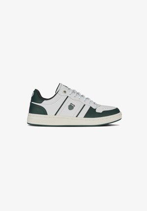 Zapatilla de cuero blanca con acentos verdes, punta redonda y suela plana. Presenta dos rayas verdes y un logo en el lado, diseño con cordones.