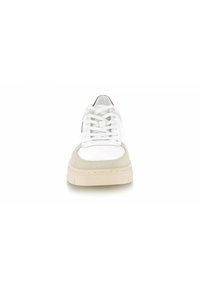 Sneaker blanche avec des accents en daim gris, lacets plats, semelle en caoutchouc et une petite étiquette verte sur le côté. La vue de face montre une surface lisse et des détails de couture.