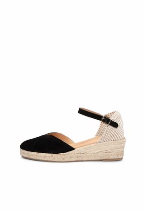 Zapato espadrille de cuña negra y beige con puntera cerrada, correa en el tobillo con hebilla y suela de yute tejida.