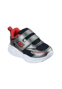 Zapatilla deportiva negra y plateada con detalles en rojo, que presenta tela de malla, dos tiras de velcro y una suela de goma blanca texturizada.