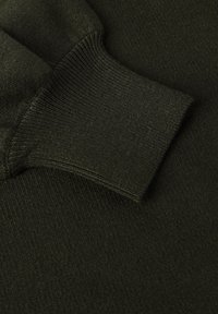 Donkergroen trui-stof met een geribbelde manchetdetail, gladde textuur en een gestructureerde pasvorm. Materiaal lijkt zacht en duurzaam.