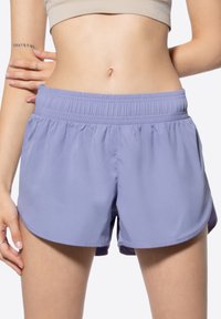 Shorts de sport lavande clair avec une taille élastique, un tissu doux et un ourlet arrondi, conçus pour le confort et la liberté de mouvement.