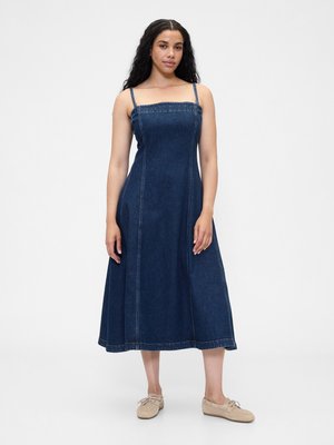 Denimklänning med fyrkantig halsringning, tunna remmar och en svängd midi-längd. Mörkblå tyg med synliga sömdetaljer.