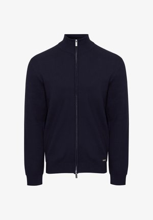 Marineblå trøje med lynlås og høj krave, lavet af glat, fleksibelt stof. Har lange ærmer og et diskret logo ved kanten.