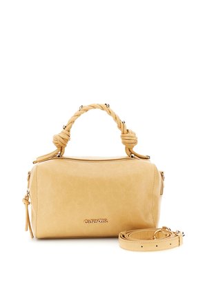 Sac à main en cuir beige avec poignée tressée, logo doré, fermeture éclair et bandoulière amovible enroulée à côté sur fond blanc.
