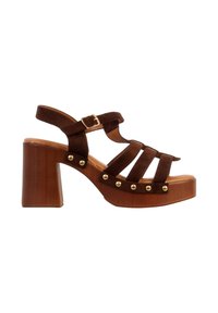 Sandale plateforme en daim marron avec talon en bois épais, bride de cheville à boucle dorée et détails de clous dorés le long du bord de la semelle.