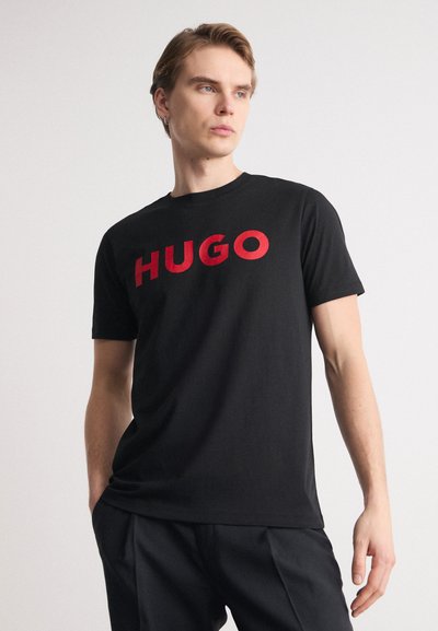 Черен памучен потник с думата "HUGO" в дебели червени букви отпред. Къси ръкави, кръгло деколте и удобен крой.